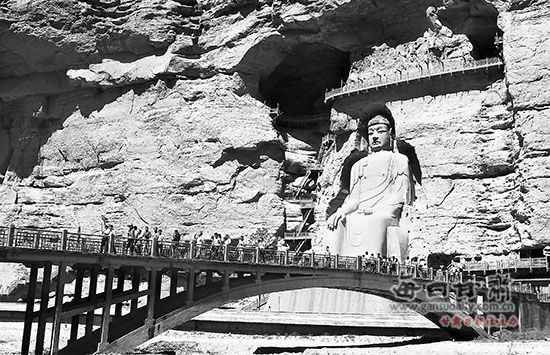 8月21日,游客在永靖县炳灵寺石窟参观。入秋以来，位于永靖县境内的炳灵寺石窟进入旅游接待高峰期，景区内的丹霞地貌、石窟艺术等吸引了国内外大批游客前来观光旅游。