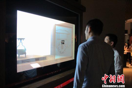 5月15日，新“甘肃丝绸之路文明”展览在甘肃省博物馆正式对外开放。图为动静结合展示国宝级文物鼎形铜行灯引观众围观。　甘肃省博物馆供图 摄