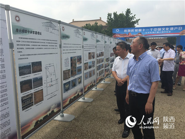 陕西省文物局局长赵荣等领导观看活动展板。