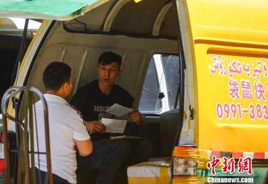 新疆乌鲁木齐市二道桥附近,一位“快递小哥”正在为顾客登记所发货物的清单,一如往常一样收件、发件,坚守岗位。(摄于6月21日) 刘新 摄 新疆乌鲁木齐市二道桥附近,一位“快递小哥”正在为顾客登记所发货物的清单,一如往常一样收件、发件,坚守岗位。(摄于6月21日) 刘新 摄