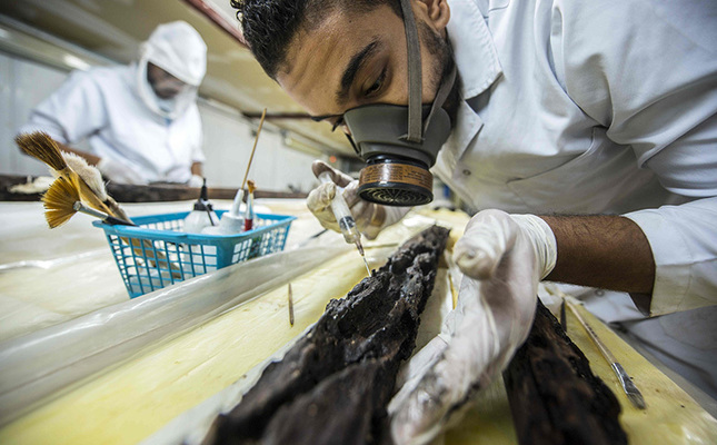 Egyptian archaeologist Mohamed Anwar works on parts of the second solar boat of Pharaoh Khufu on Aug 31, 2016 at the restoration laboratory, located behind the Great Pyramid of Cheops, on the southern outskirts of the capital Cairo. (AA Photo)