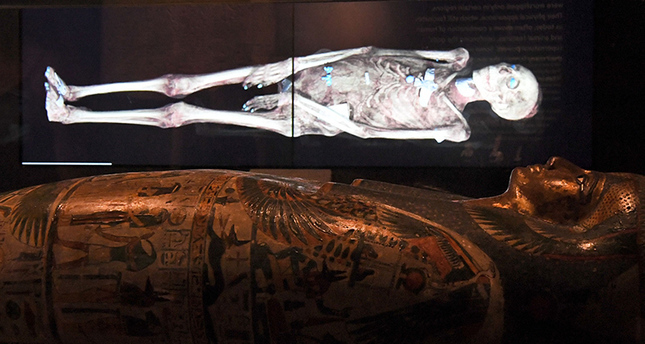 A three-dimensional image of a CT scan of an Egyptian mummy is projected above a sarcophagus (AFP Photo)