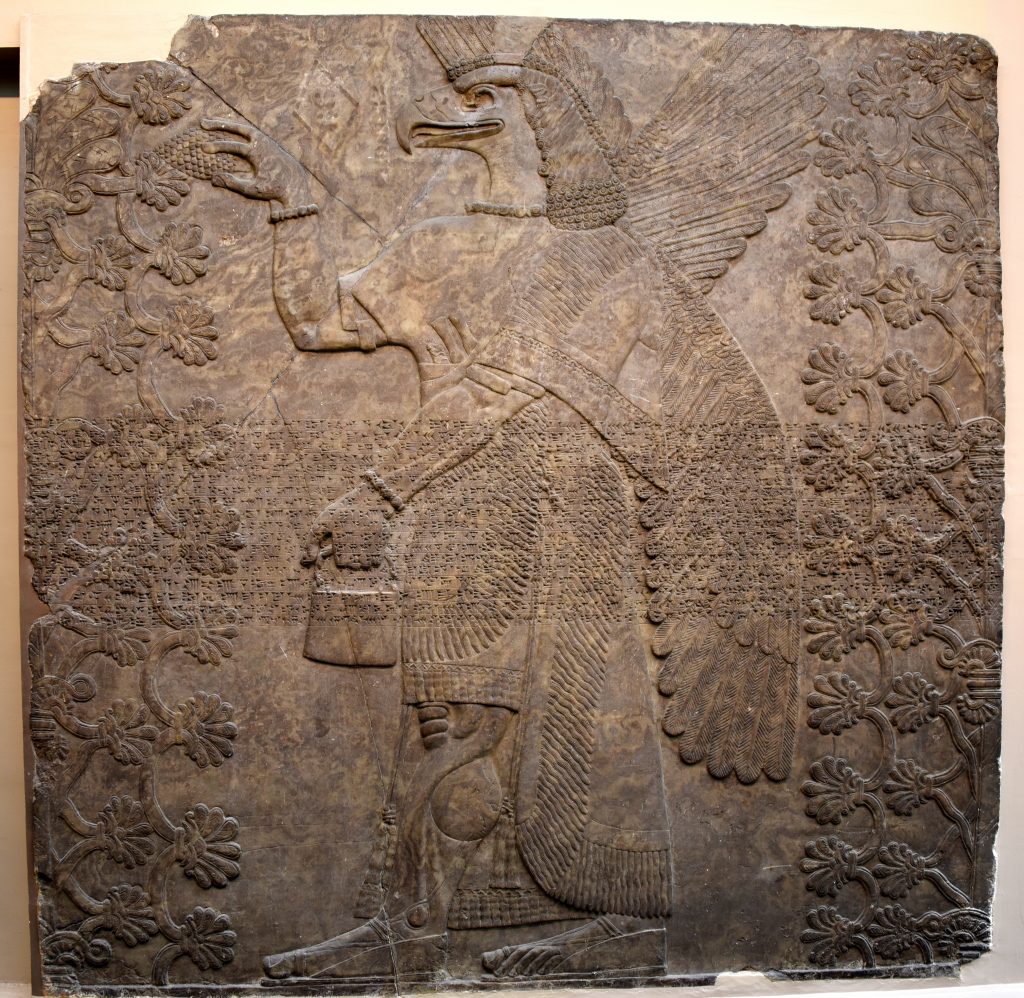 An eagle-headed and winged man (Apkallu, Sage, or protective spirit) stands in the middle of the panel and is flanked by 2 sacred trees. He wears a long fringed and equisityl carved robe. There are bracelets and armlets. The anatomy of the muscles of the arms and legs are highlighted, conveying the message that he is a powerful creature. His left hand holds a bucket while the right one holds a cone. This is part of a ceremonial religious rite. From the North-West Palace at Nimrud, Room F, panel 8. Northern Mesopotamia, modern-day Iraq. Assyrian, 865-860 BCE. The British Museum, London. Photo © Osama S. M. Amin. 