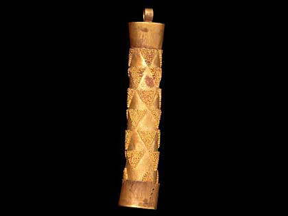 a golden cylinder with triangular decoration