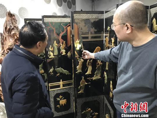 陈晖向来宾展示日本回流的福州寿山石屏风珍品。 郑松波 摄 陈晖向来宾展示日本回流的福州寿山石屏风珍品。 郑松波 摄