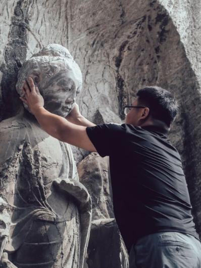 9月23日，龙门西山奉先寺北壁，一件一比一3D打印的佛首被龙门石窟研究院工作人员安放在一尊等身立佛的残像上。