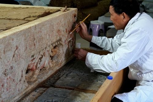 工作人员在对石棺床的彩绘进行加固。新华社记者李安摄