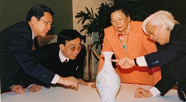 汪庆正(右一)与香港张永珍女士等鉴赏清雍正粉彩蝠桃纹橄榄瓶