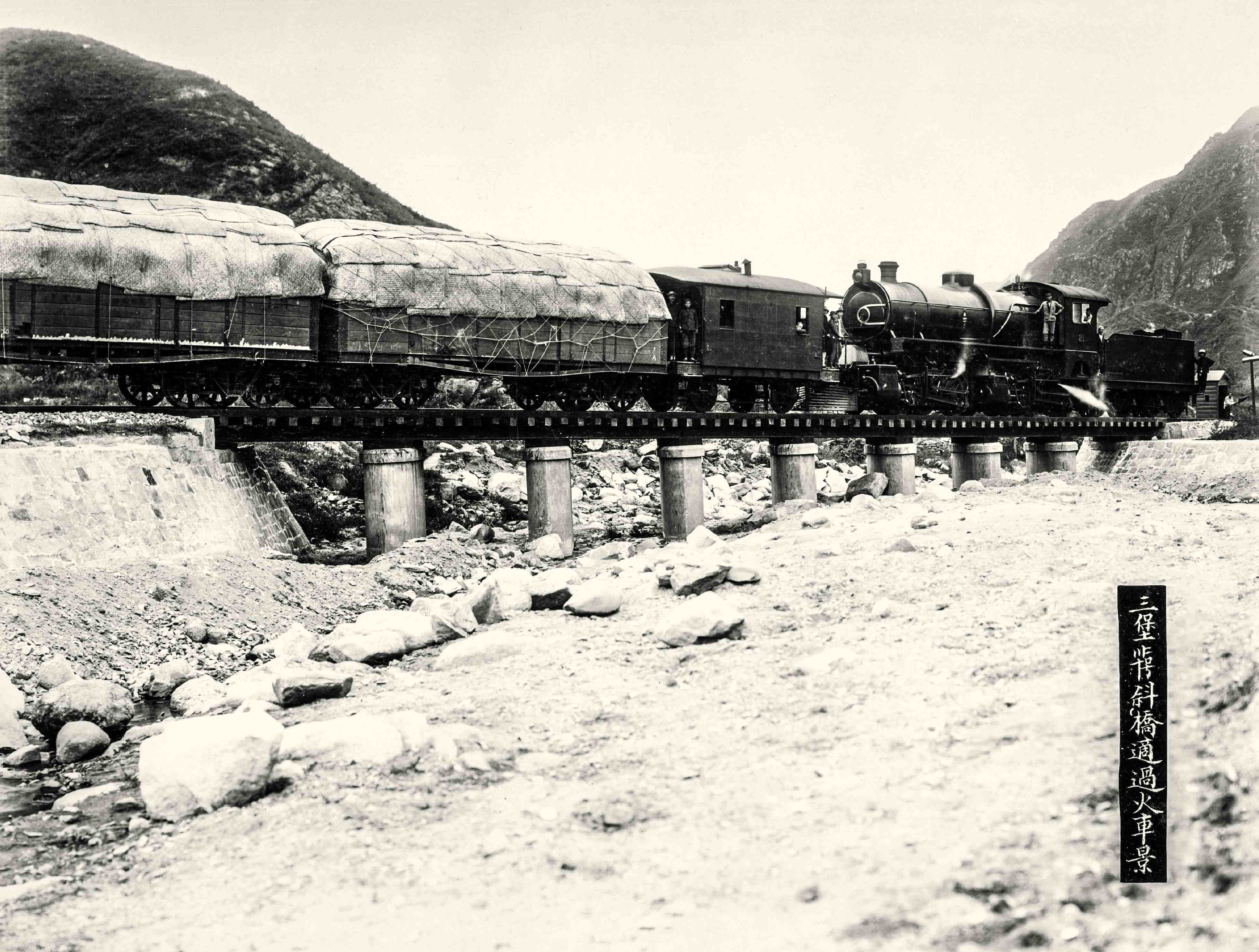 验道专车。1909年10月2日,京张铁路在南口举行通车典礼。这幅照片拍摄于验道专列出发前。前排为工程技术人员,前排右起第三人是总工程司詹天佑。后排为满载铁路工人的验道专车。验道专车从南口车站出发,詹天佑在官员乘坐的验道专车的头等车厢后加挂了两节浅箱货车,里面乘坐的是学习验收的铁路工人。