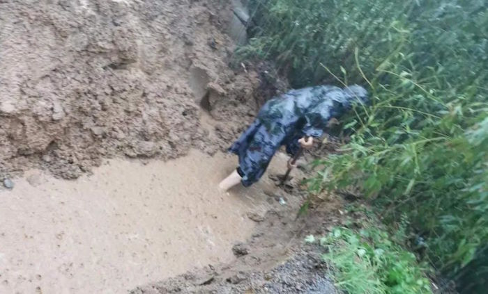 鹤壁辛村遗址考古工作人员雨中排水。(河南省文物局供图)