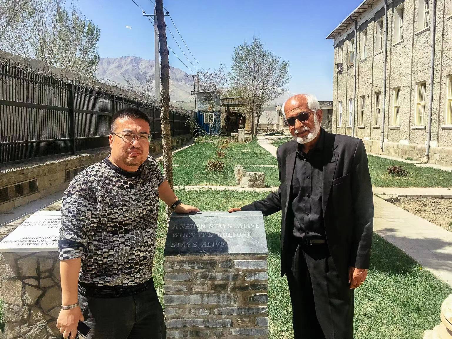 与喀布尔阿富汗国立博物馆的前任馆长奥玛尔·汗·玛苏迪合影,旁边石碑刻的就是那句著名的“A nation stays alive when its culture stays alive(文化不灭,国家永生)。