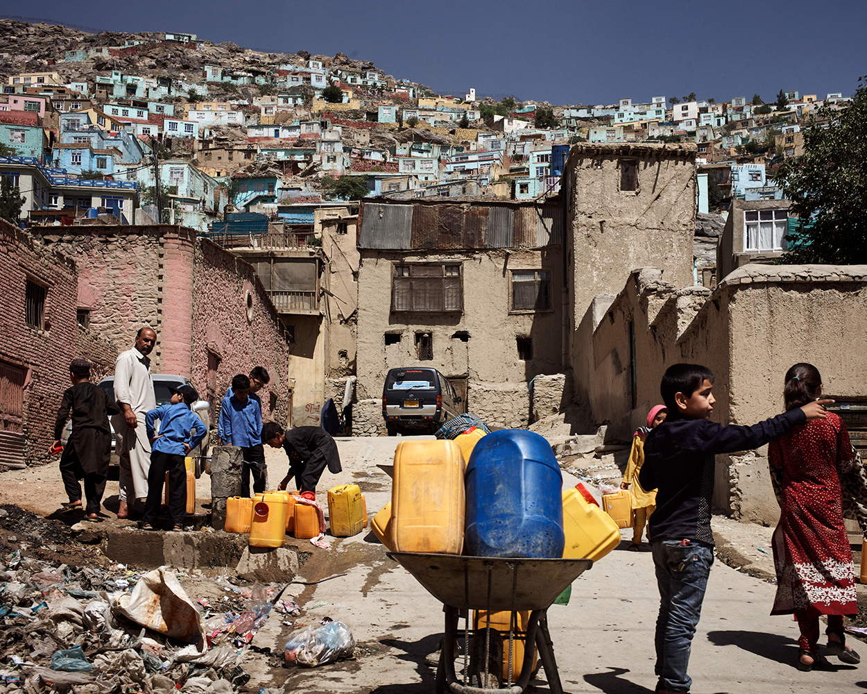 2018年，喀布尔山区的贫民区，正在打水的孩子们。