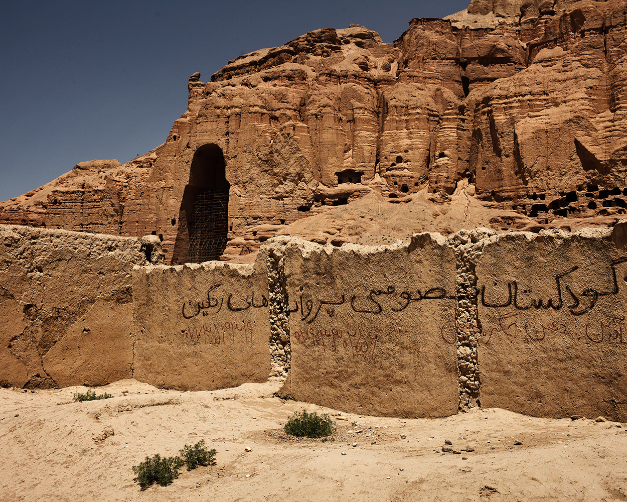 2018年，巴米扬大佛西窟的空洞，前面是写有标语的土坯墙。