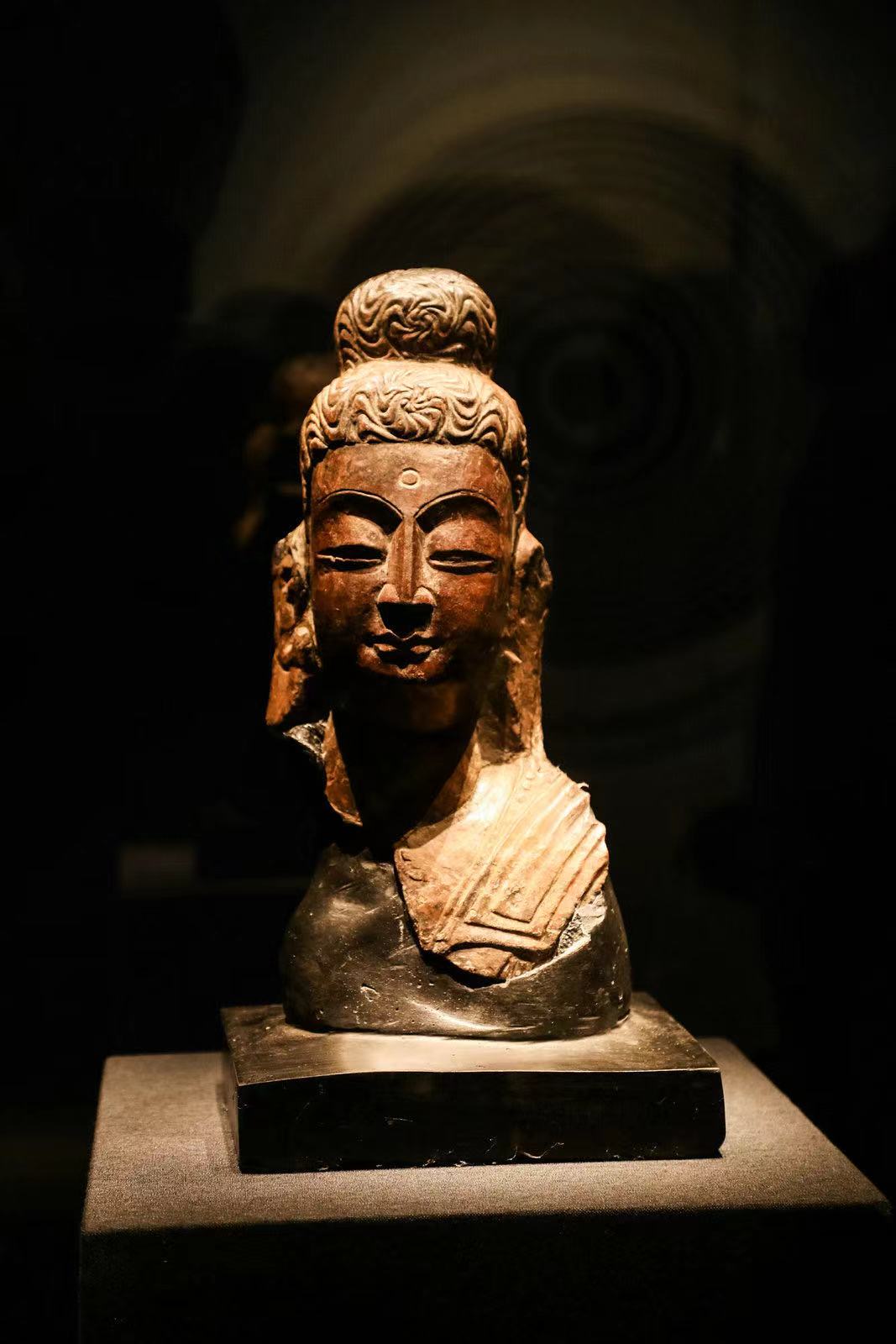 佛头像,国家一级文物,北魏(386~534年),高32、宽14、厚12.5厘米,原龙门石窟西山古阳洞高树等造像龛佛头,2005年10月回归龙门石窟。 佛像系北魏后期龙门佛教造像艺术“秀骨清像”的范例,20世纪初期被盗凿,运往法国,后流落比利时,1991年由美籍华人陈哲敬收藏。1992年专家确认为古阳洞北壁高树解伯都等三十二人造像龛主尊的头部,该龛造像题记为龙门二十品之一。