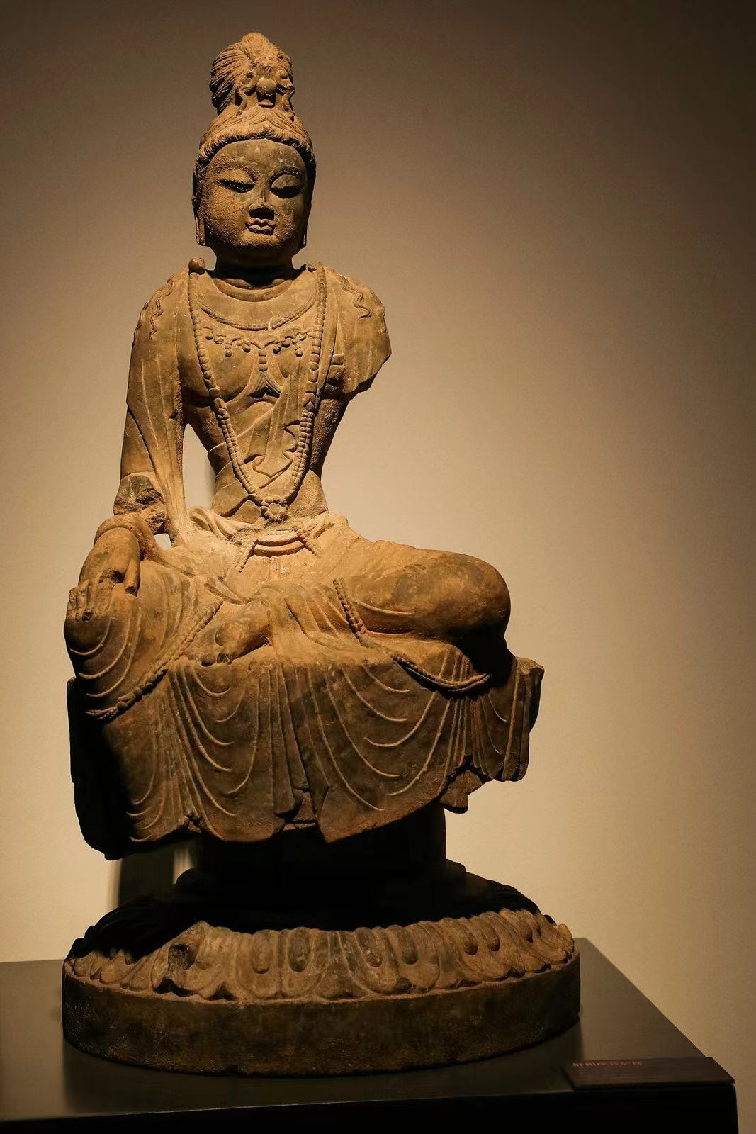 舒相座菩萨像,国家一级文物,唐(618~907年),高86.5、宽44、厚45厘米,2000年龙门石窟西山奉先寺遗址出土 该菩萨面部丰满圆润,肌肉写实,身饰项圈、帔帛与璎珞;腰束大裙,腰部细窄而鼓腹,半跏趺坐于束腰莲花台座上。宽大轻薄的裙裾覆盖莲台,衣纹简练流畅,莲瓣刚劲有力,呈现了盛唐雍容华贵的菩萨姿态。