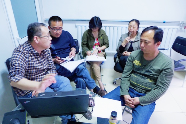 饰件装配小组在讨论相关问题,唯独少了邓天珍,她在给我们拍照